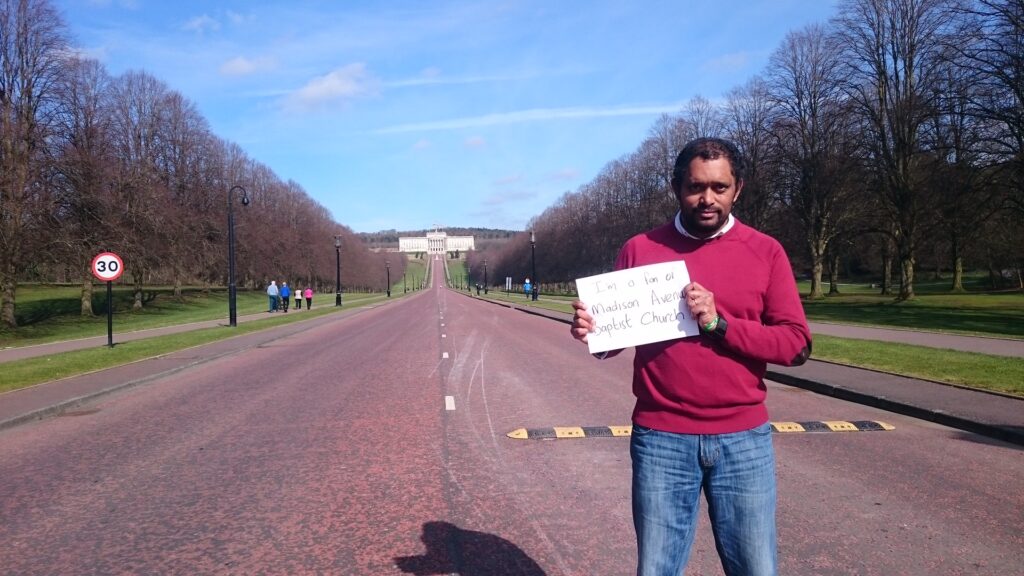 Church member holding an MABC sign on a tree-lined avenue in Phoenix Park, Dublin